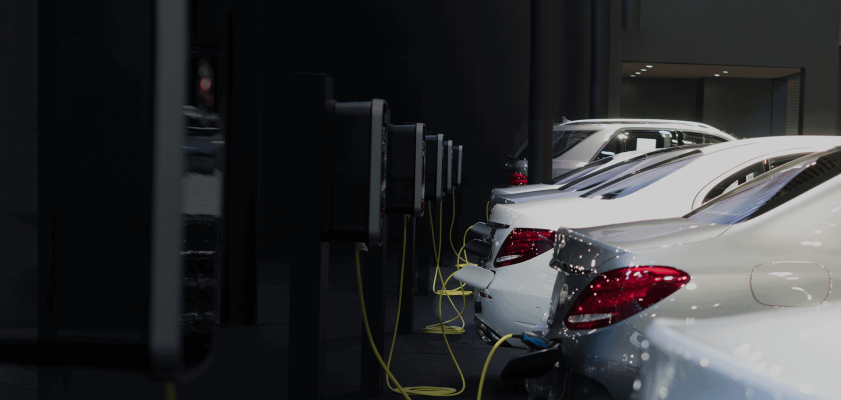 Parking garage with cars plugged into EV chargers.